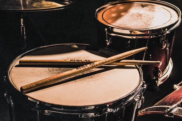 Photo of drum sticks on a snare, photo by Matthijs Smit on Unsplash